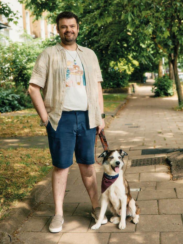 man with beard wearing shirt and holding dog
